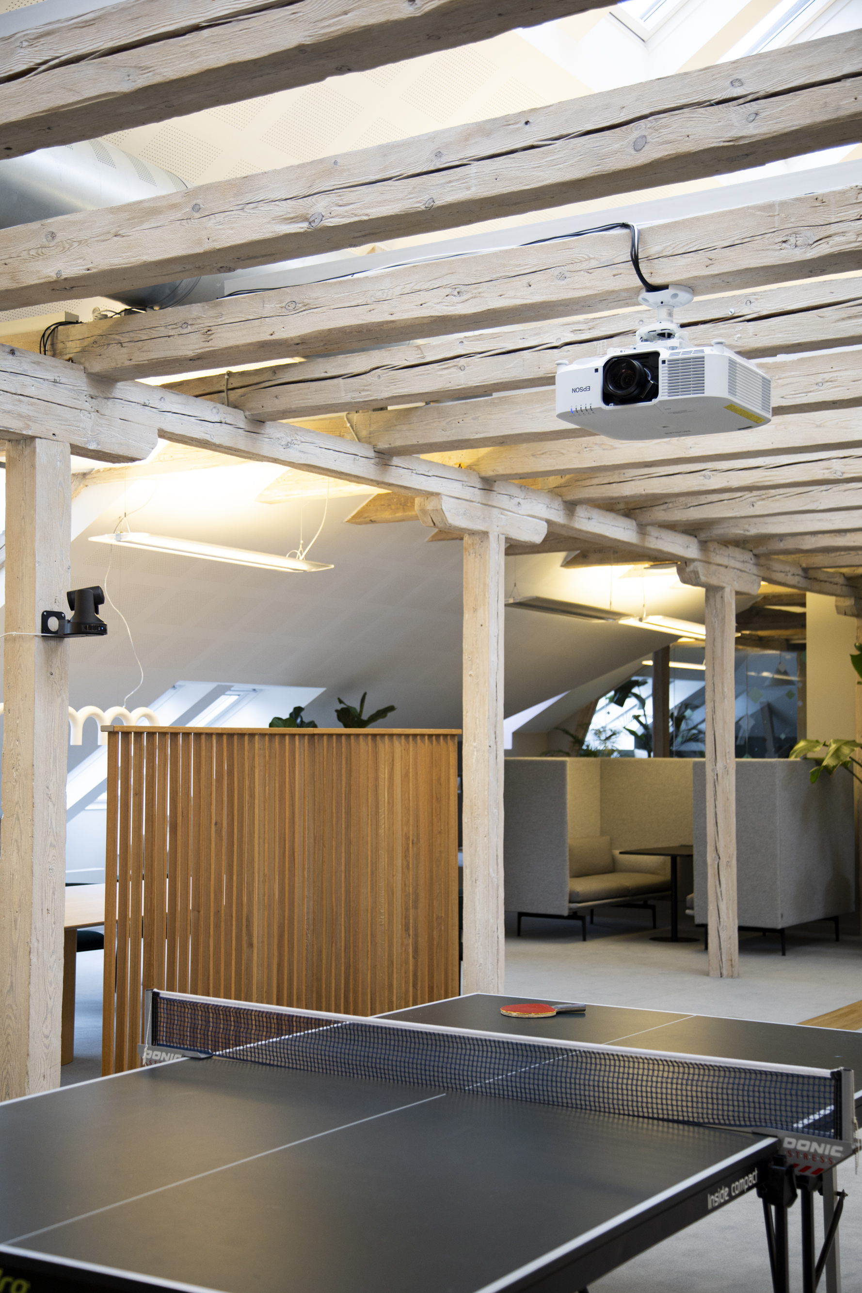Moderne fællesområder med integrerede AV‑ og projektorløsninger, der understøtter både arbejde, pauser og sociale aktiviteter.